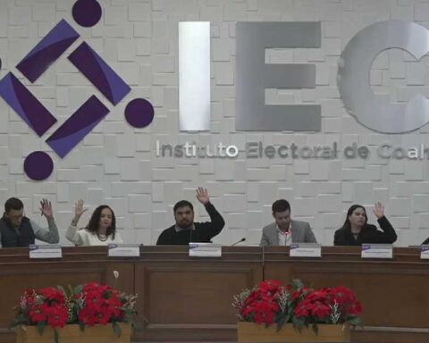 Consejeros electorales levantando la mano para votar.