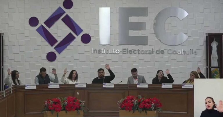 Consejeros electorales levantando la mano para votar.