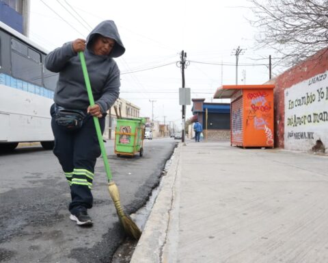 Mujer del programa Aquí Andamos barriendo una calle en Saltillo.