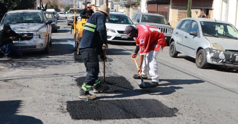 Trabajadores reparando pavimento de una calle en Saltillo.