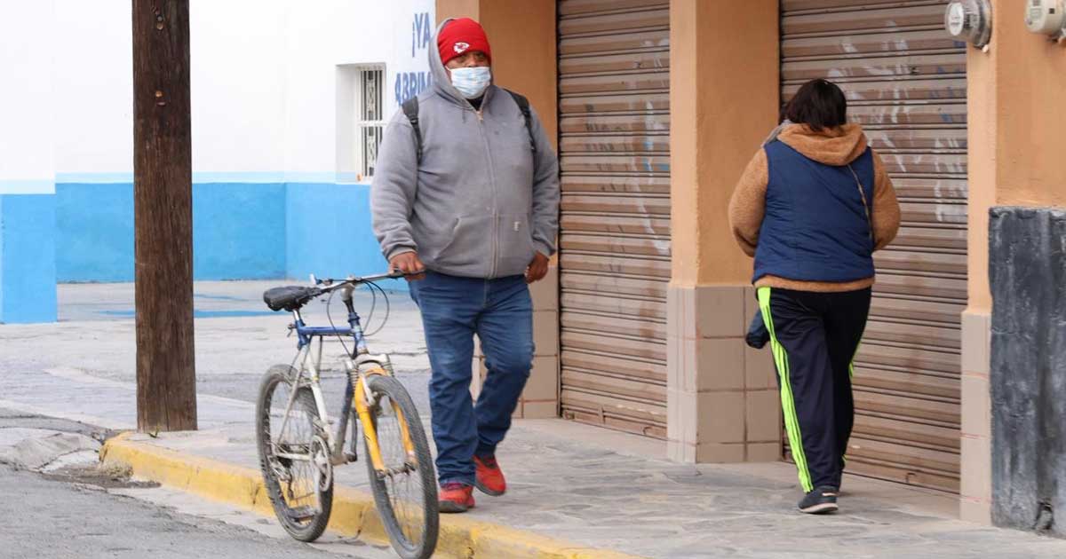 Personas caminando abrigadas por calles de Parras de la Fuente.