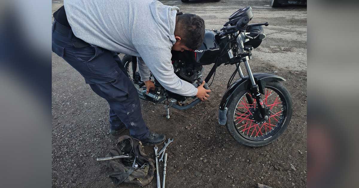 Hombre revisando una motocicleta.