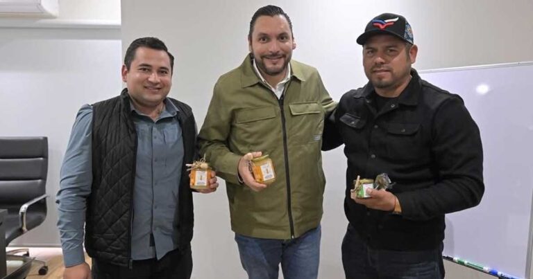 Alcalde Carlos Villarreal y empresarios sosteniendo tarros de miel.