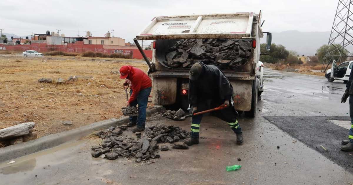 Trabajadores levantando lodo en calles de Saltillo.