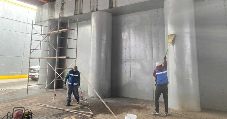 Trabajadores pintando los muros de los puentes vehiculares en Torreón.