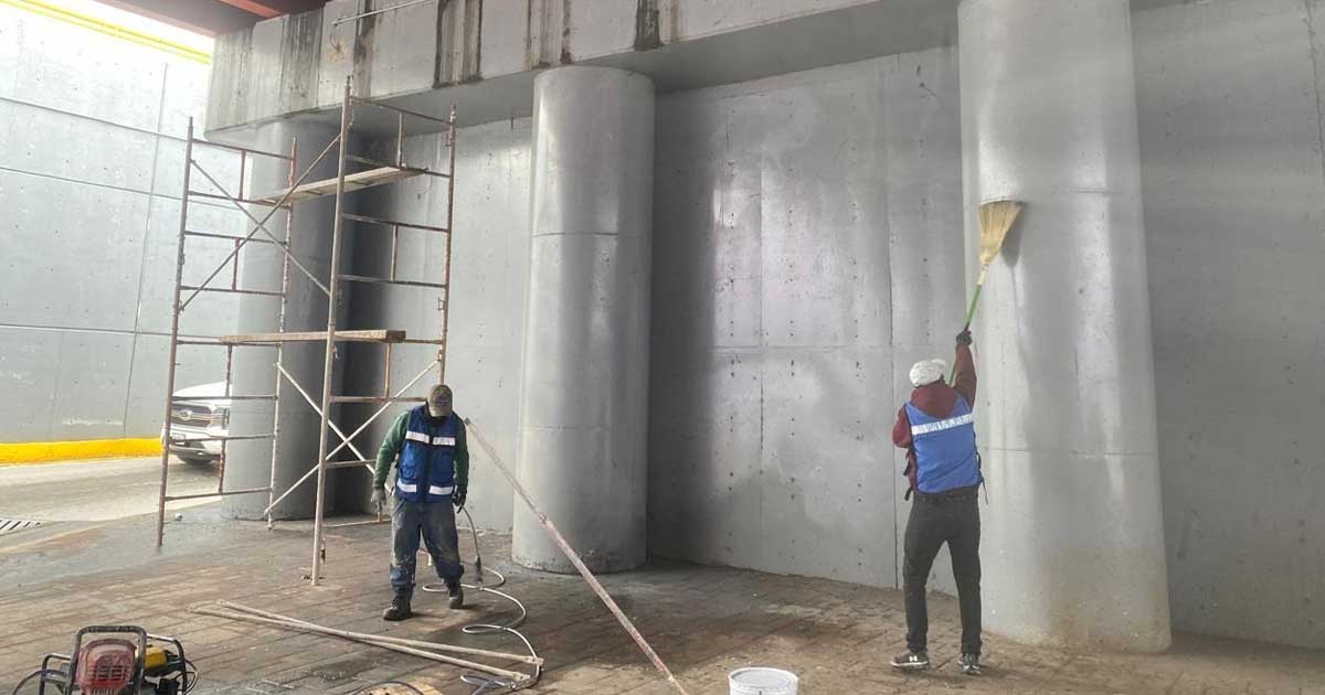 Trabajadores pintando los muros de los puentes vehiculares en Torreón.