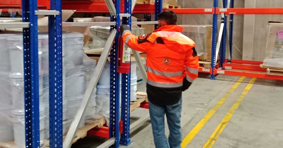 Elemento de Protección Civil revisando extintores en una empresa.
