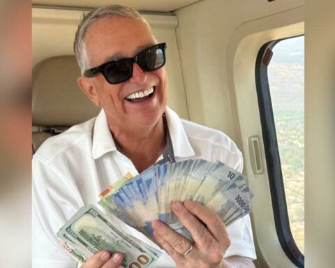 El empresario Ricardo Salinas Pliego sosteniendo un fajo de billetes mexicanos.
