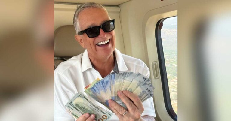 El empresario Ricardo Salinas Pliego sosteniendo un fajo de billetes mexicanos.