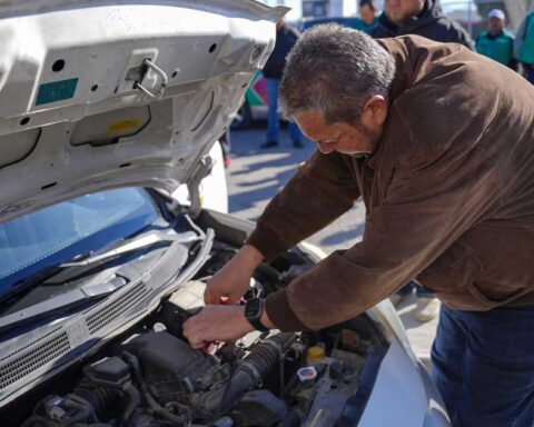 Alcalde de Ramos Arizpe Tomás Gutiérrez revisando el motor de un vehículo.
