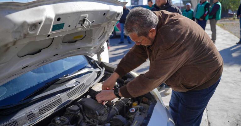 Alcalde de Ramos Arizpe Tomás Gutiérrez revisando el motor de un vehículo.