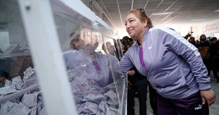 Mujer sacando un boleto de una urna para el sorteo en Saltillo.