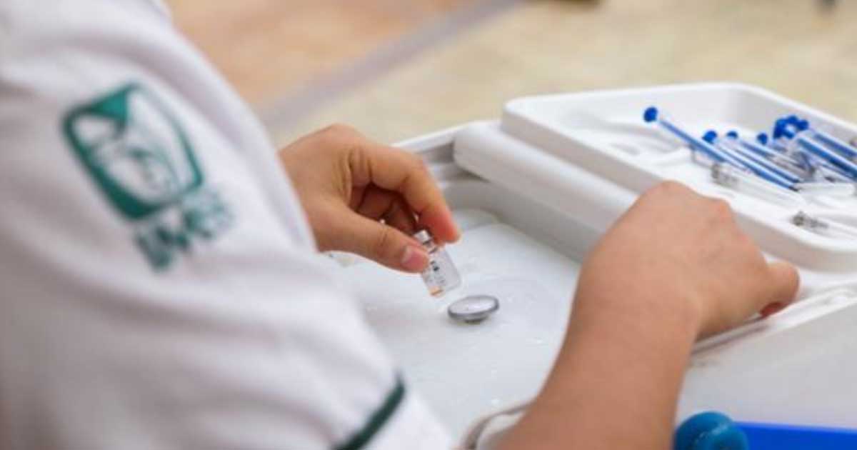 Enfermera del IMSS con una vacuna.