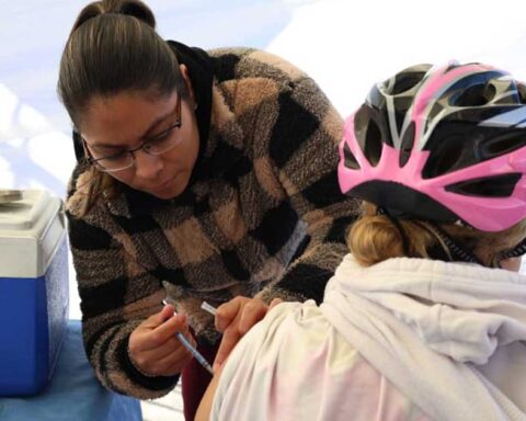 Mujer vacunando a una persona.