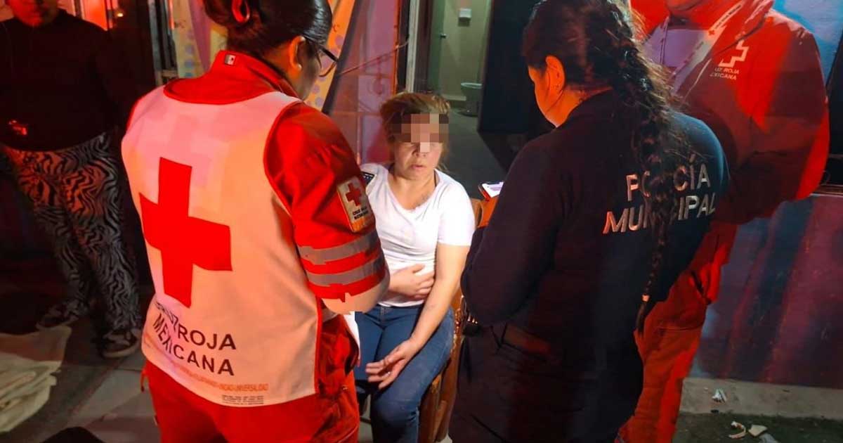 Mujer siendo atendida por paramédicos y una agente de la Policía Municipal en Torreón.