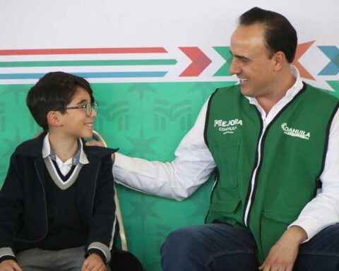 Manolo Jiménez, gobernador de Coahuila, con un estudiante de primaria.