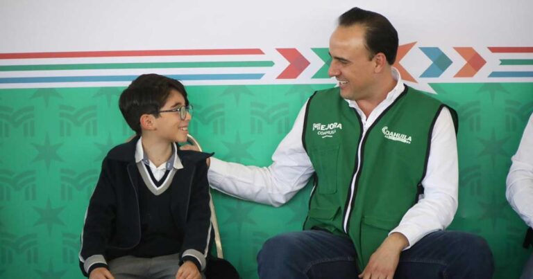 Manolo Jiménez, gobernador de Coahuila, con un estudiante de primaria.