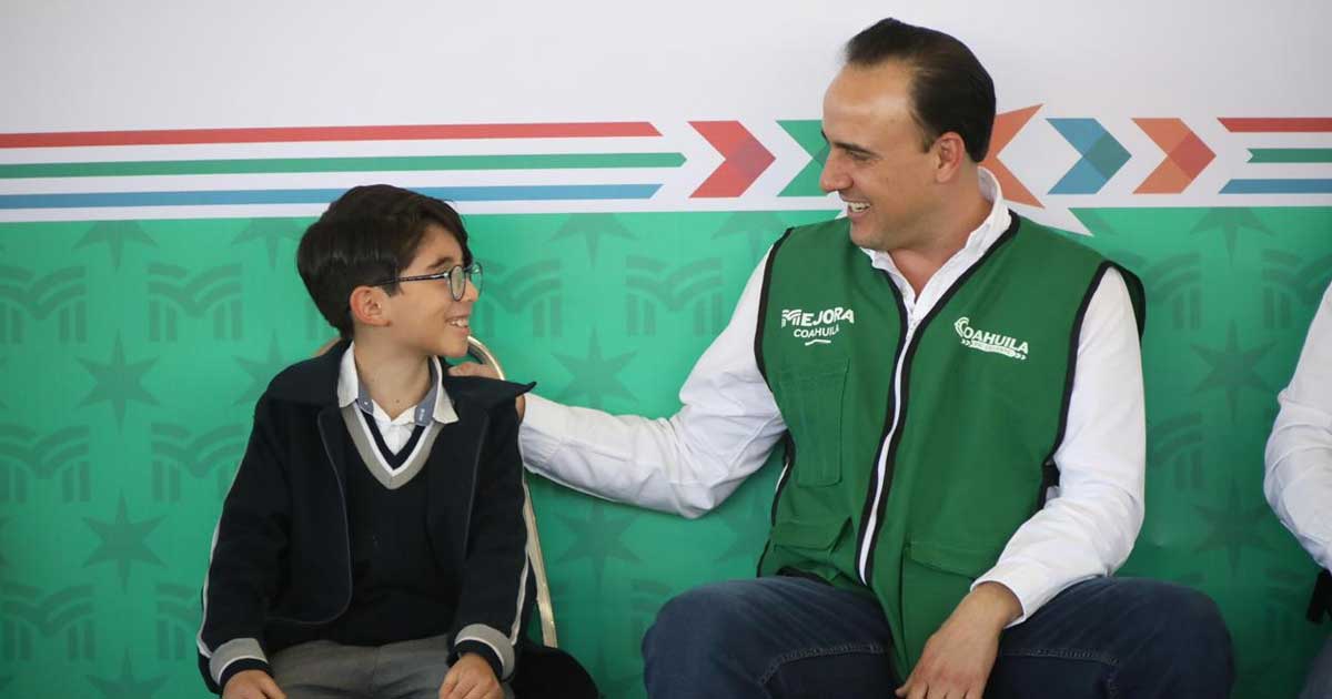 Manolo Jiménez, gobernador de Coahuila, con un estudiante de primaria.