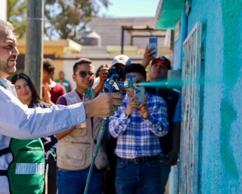 Alcalde de Ramos Arizpe Tomás Gutiérrez aplicando pintura a una fachada.