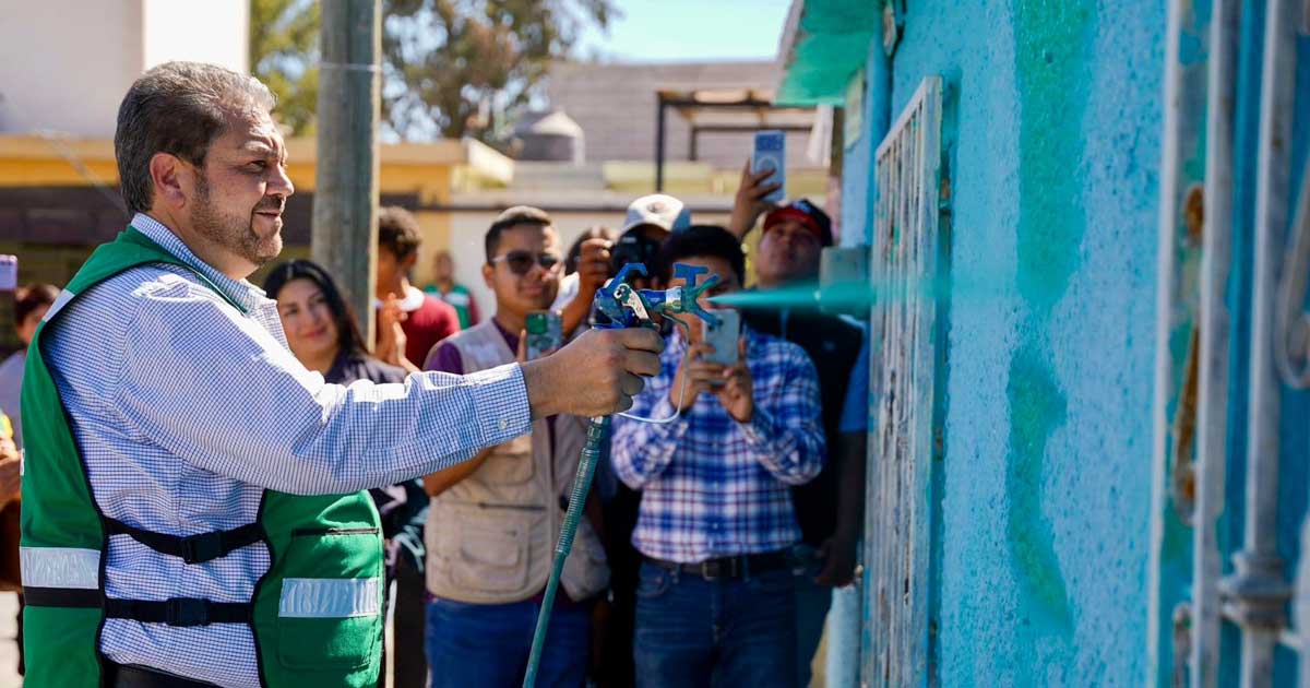 Alcalde de Ramos Arizpe Tomás Gutiérrez aplicando pintura a una fachada.