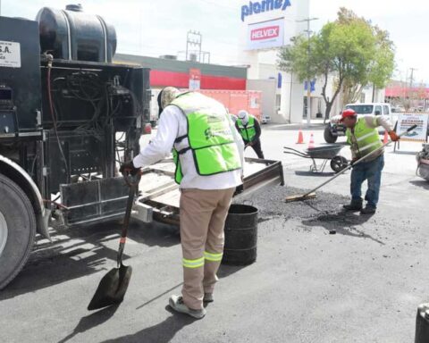 Trabajdores reparando el asfalto en una calle de Saltillo.