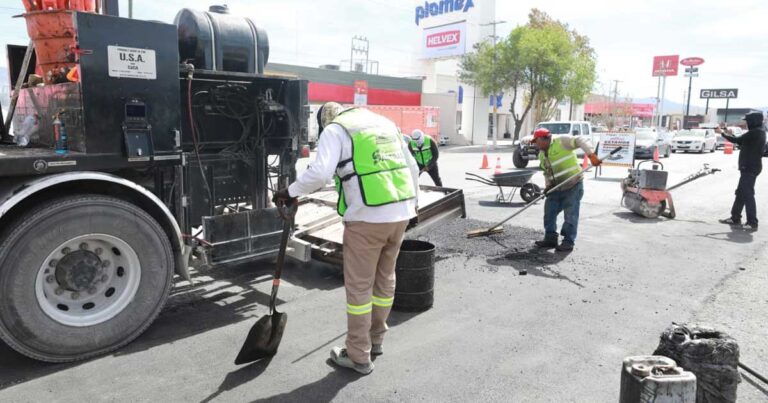 Trabajdores reparando el asfalto en una calle de Saltillo.