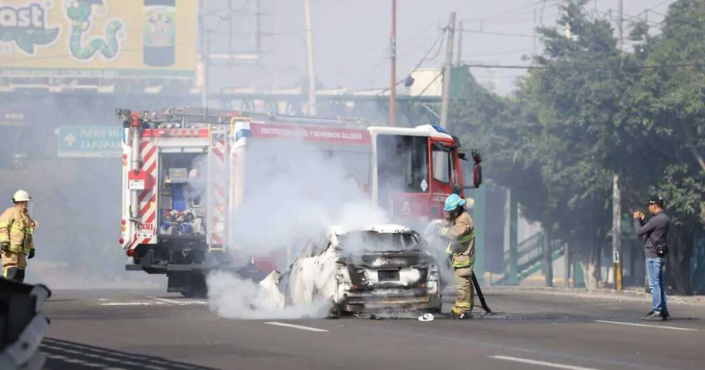 Bomberos sofocando el incendio de un automóvil en Quintana Roo.