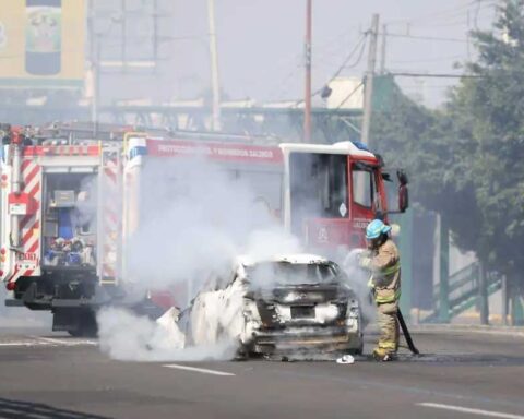 Bomberos sofocando el incendio de un automóvil en Quintana Roo.