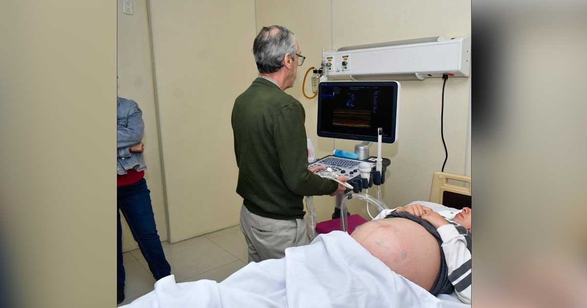 Médico utilizando el Transductor Electroacústico en una mujer embarazada,