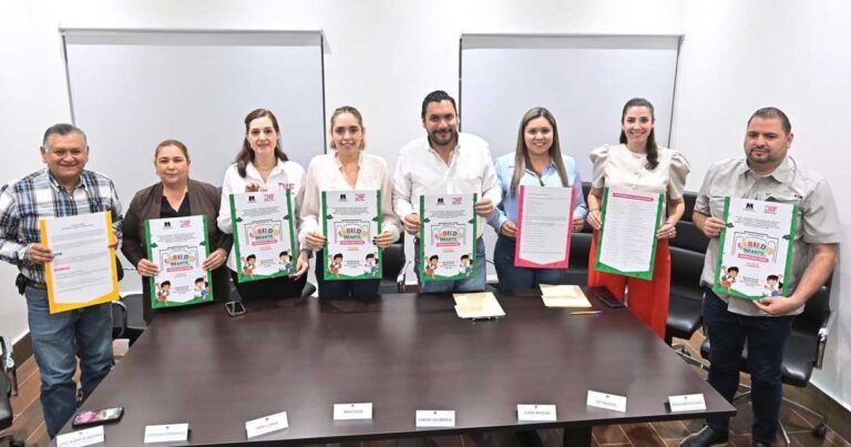Funcionarios sosteniendo la convocatoria para el Cabildo Infantil.