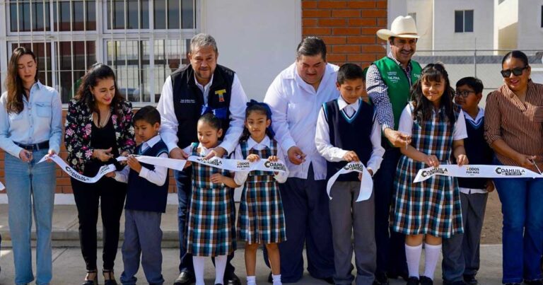 Estudiantes al frente y funcionarios atrás cortando un listón en escuela de Ramos Arizpe.