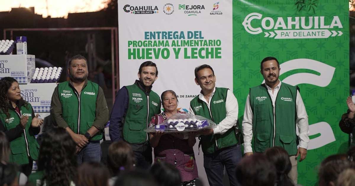 Funcionarios entregando apoyo alimentario a una mujer.