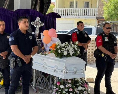 Policías haciendo guardia de honor alrededor del ataúd de la niña fallecida.