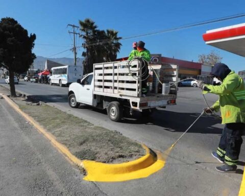 Trabajadores pintando camellón en Saltillo.