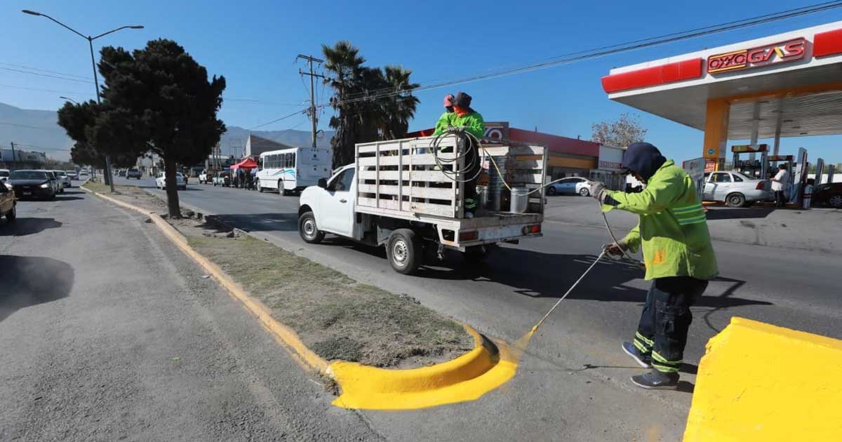 Trabajadores pintando camellón en Saltillo.