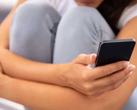 Una mujer sosteniendo un celular.