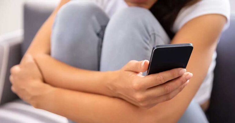 Una mujer sosteniendo un celular.