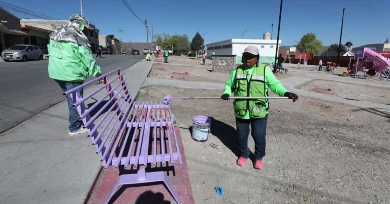 Trabajadoras pintando una banca en plaza pública al sur de Saltillo.