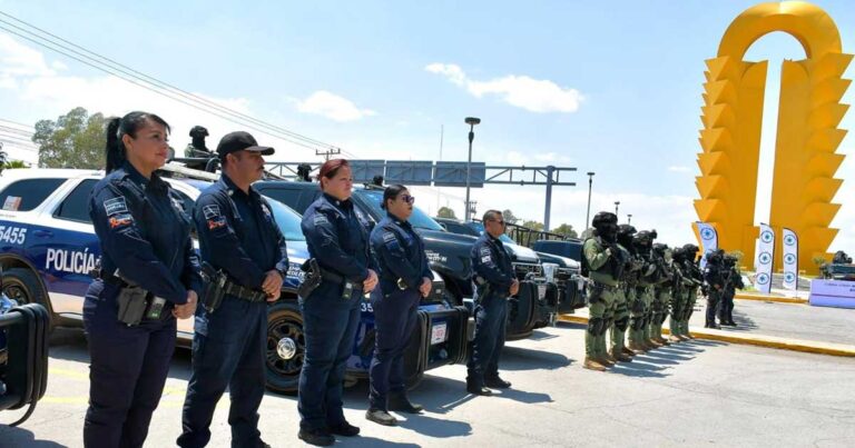 Elementos en fila delante de sus patrullas con la Puerta Amarilla de Torreón en el fondo.