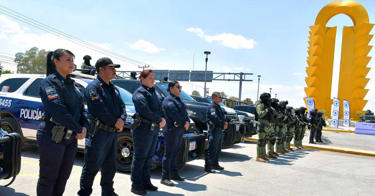 Elementos en fila delante de sus patrullas con la Puerta Amarilla de Torreón en el fondo.