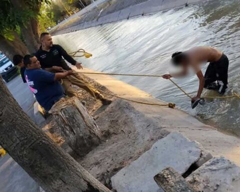 Elementos de PC sacando con una cuerda a un joven en un canal de riego en San Pedro, Coahuila.