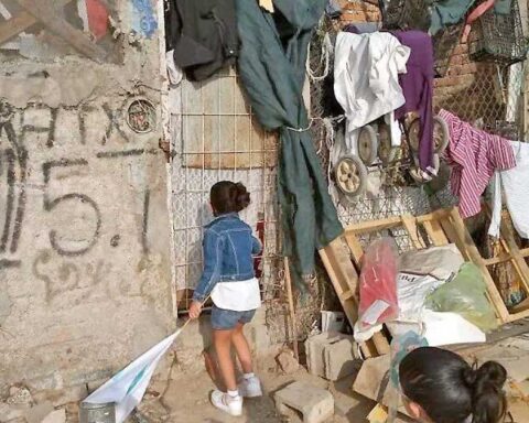 Una niña en el exterior de una casa que muestra pobreza y rezago social.