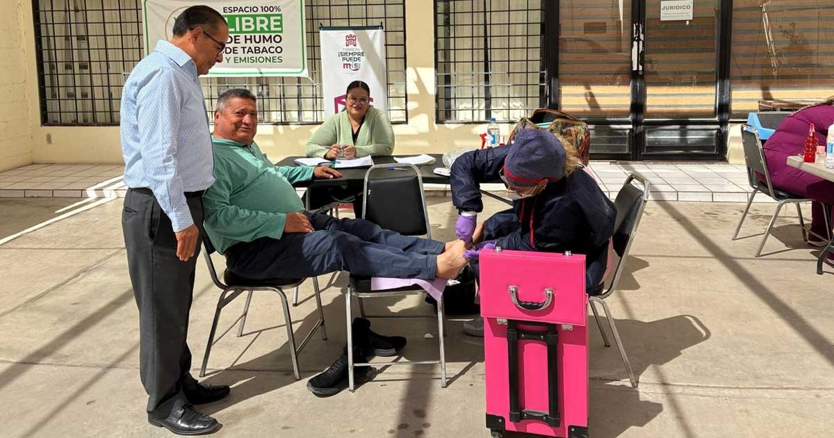 Hombre siendo atendido por una podóloga en la Dirección de Pensiones de Torreón.