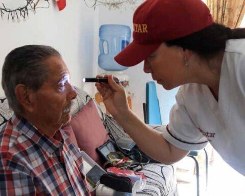 Una doctora revisando a un adulto mayor.