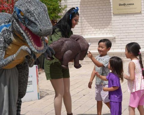 Niños acariciando un dinosaurio en Dinoandia de Ramos Arizpe.