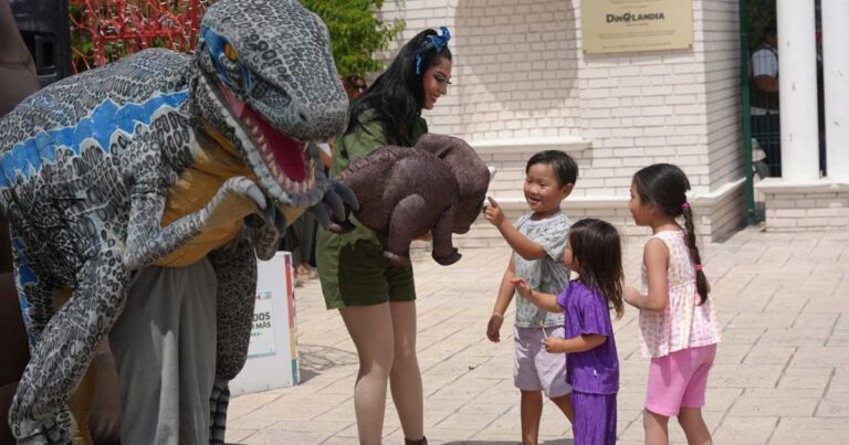Niños acariciando un dinosaurio en Dinoandia de Ramos Arizpe.