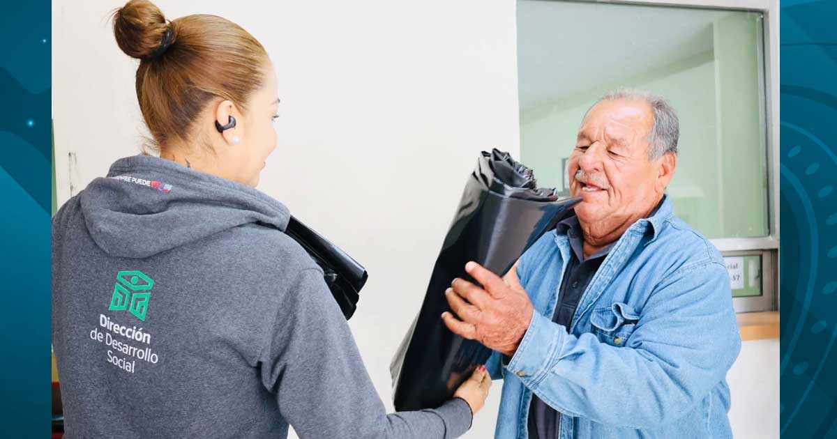 Funcionaria entregando hule a un hombre.