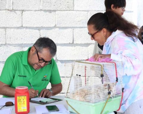 Una mujer llevando su mascota y un hombre registrando al animal.