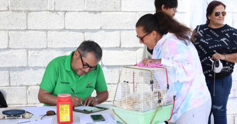 Una mujer llevando su mascota y un hombre registrando al animal.