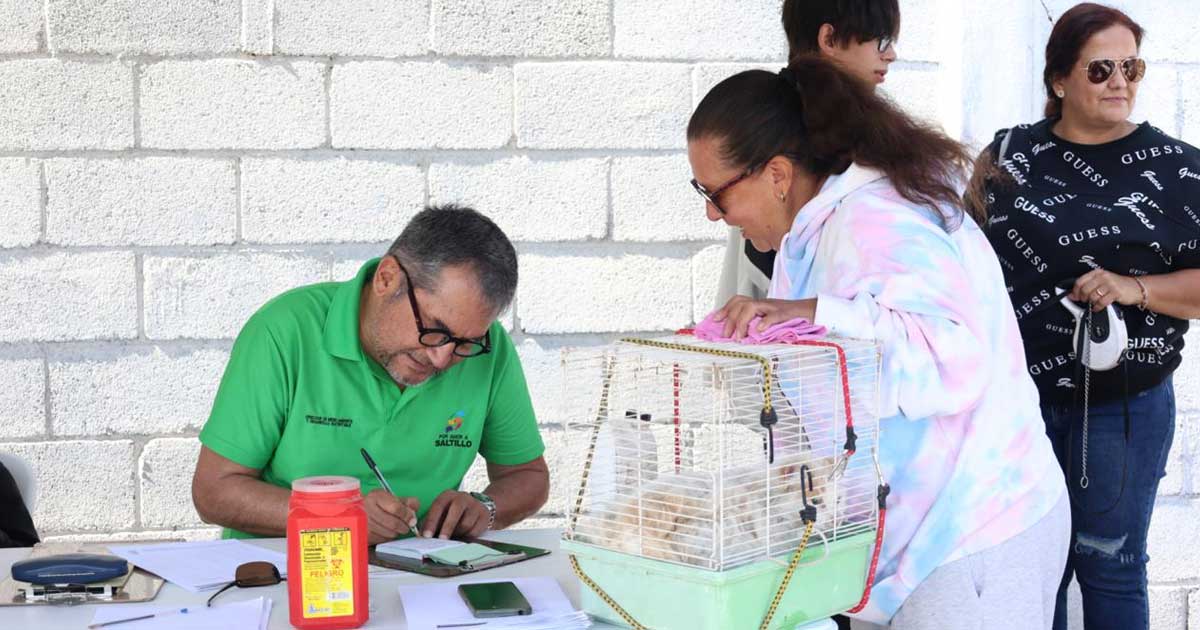 Una mujer llevando su mascota y un hombre registrando al animal.